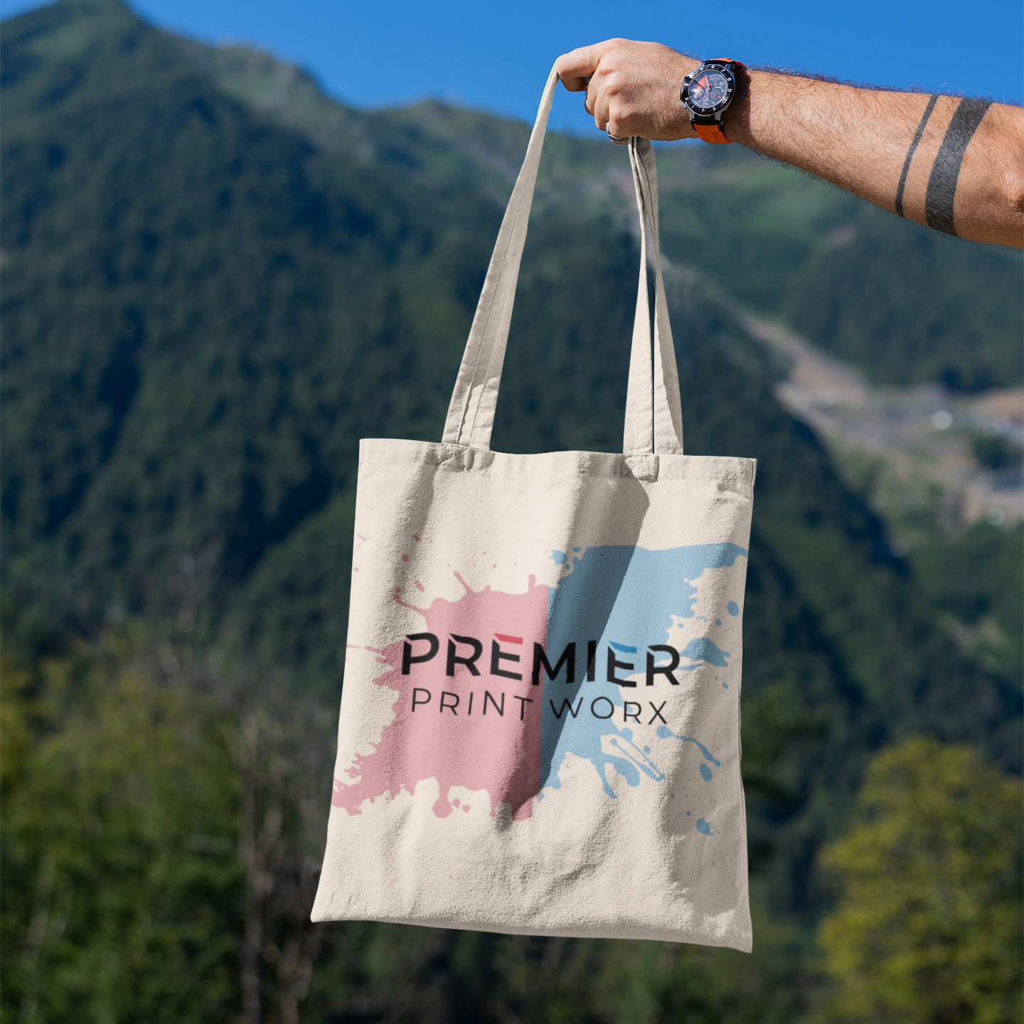 mockup-featuring-a-man-s-hand-holding-a-tote-bag-against-a-natural-scenery-3131-el1